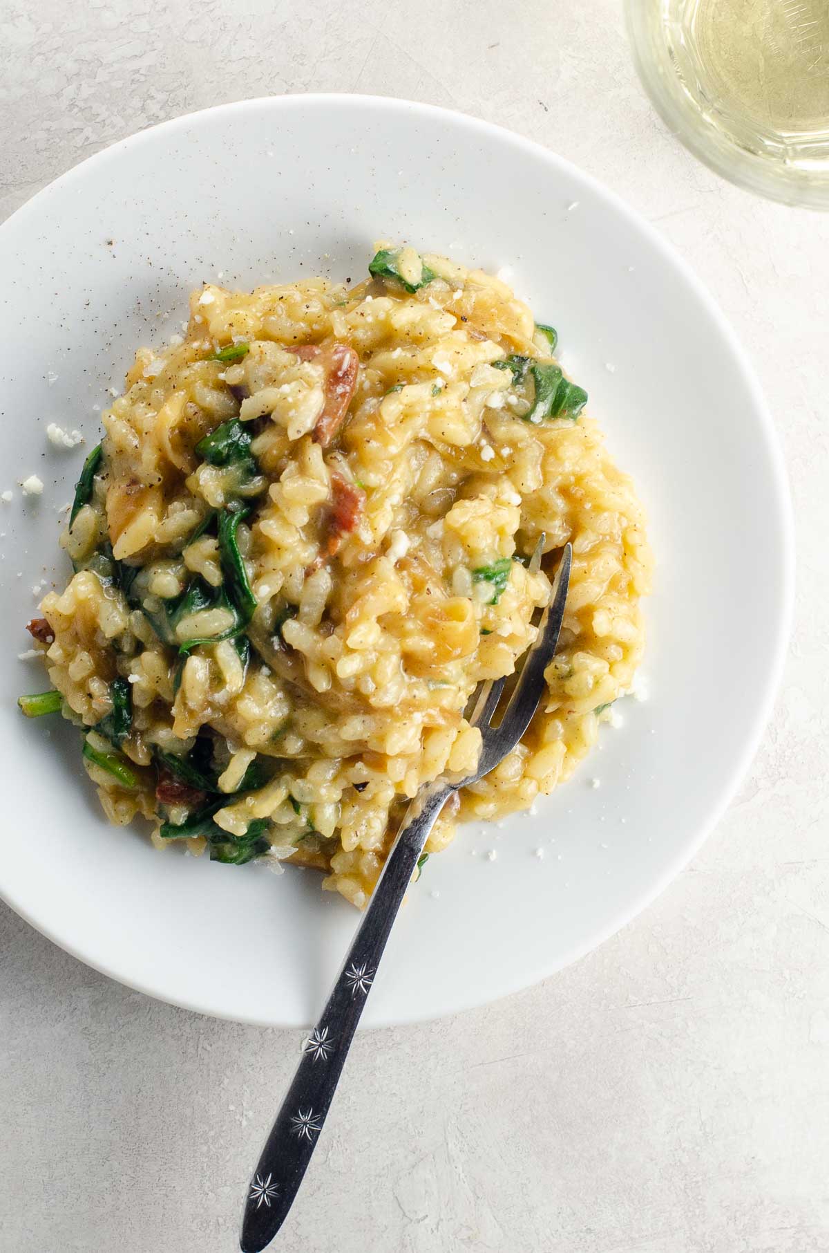 Caramelized Onion, Spinach and Bacon Risotto on a white plate
