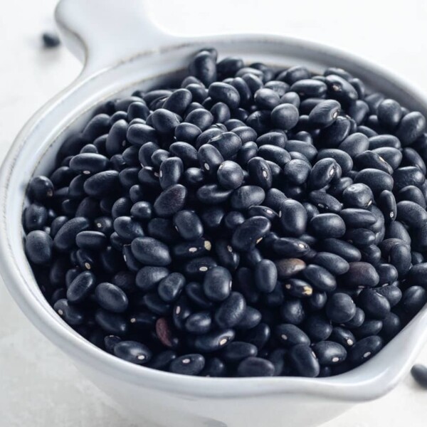 dry black turtle beans in a small white pitcher ready for cooking in instant pot, oven, or stovetop