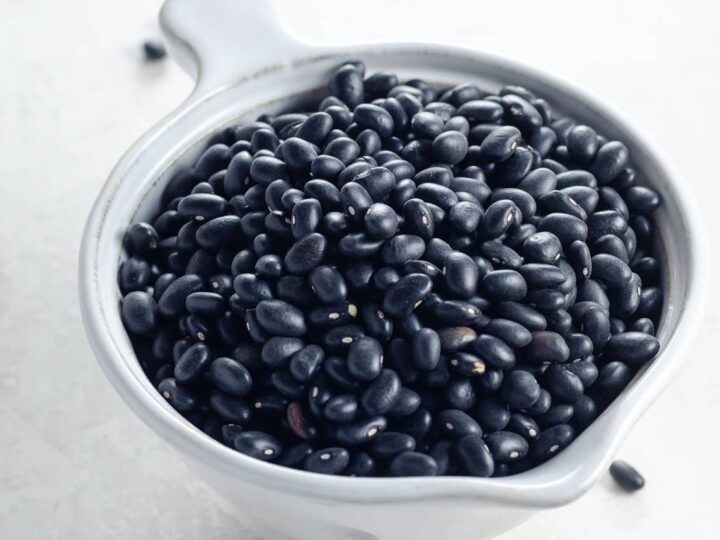 dry black turtle beans in a small white pitcher ready for cooking in instant pot, oven, or stovetop