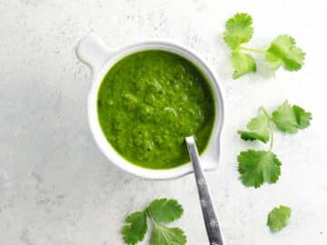 cilantro sauce in a small pitcher with a spoon