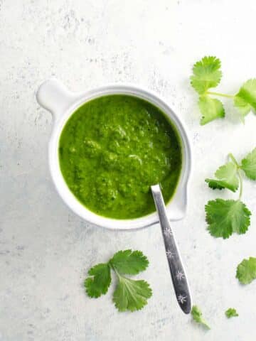 cilantro sauce in a small pitcher with a spoon
