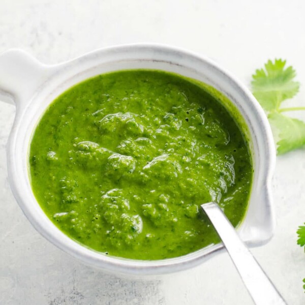 cilantro sauce in a small pitcher with a spoon