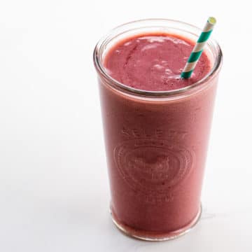 strawberry shortcake smoothie in a glass with a straw