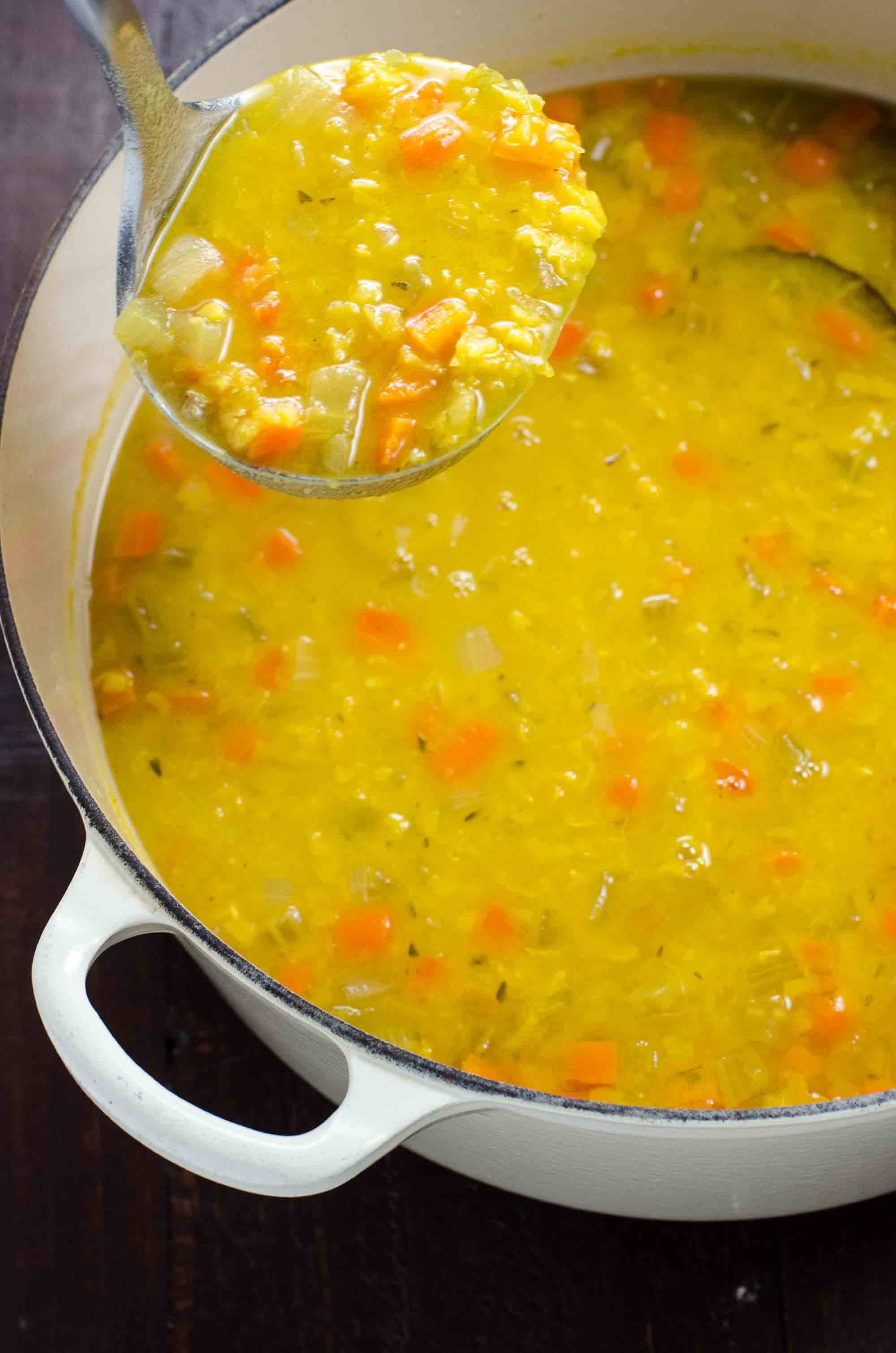 vegan split pea soup with turmeric in a pot with a ladle