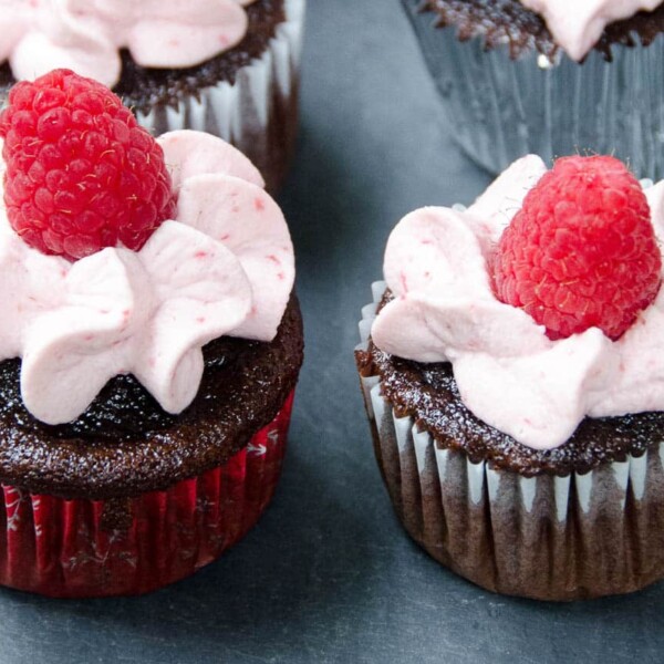 large batch chocolate cupcakes with raspberry whipped cream frosting