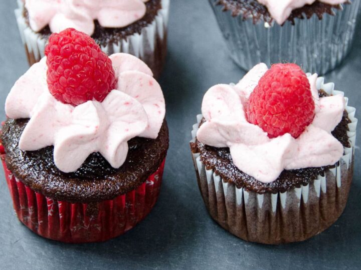large batch chocolate cupcakes with raspberry whipped cream frosting