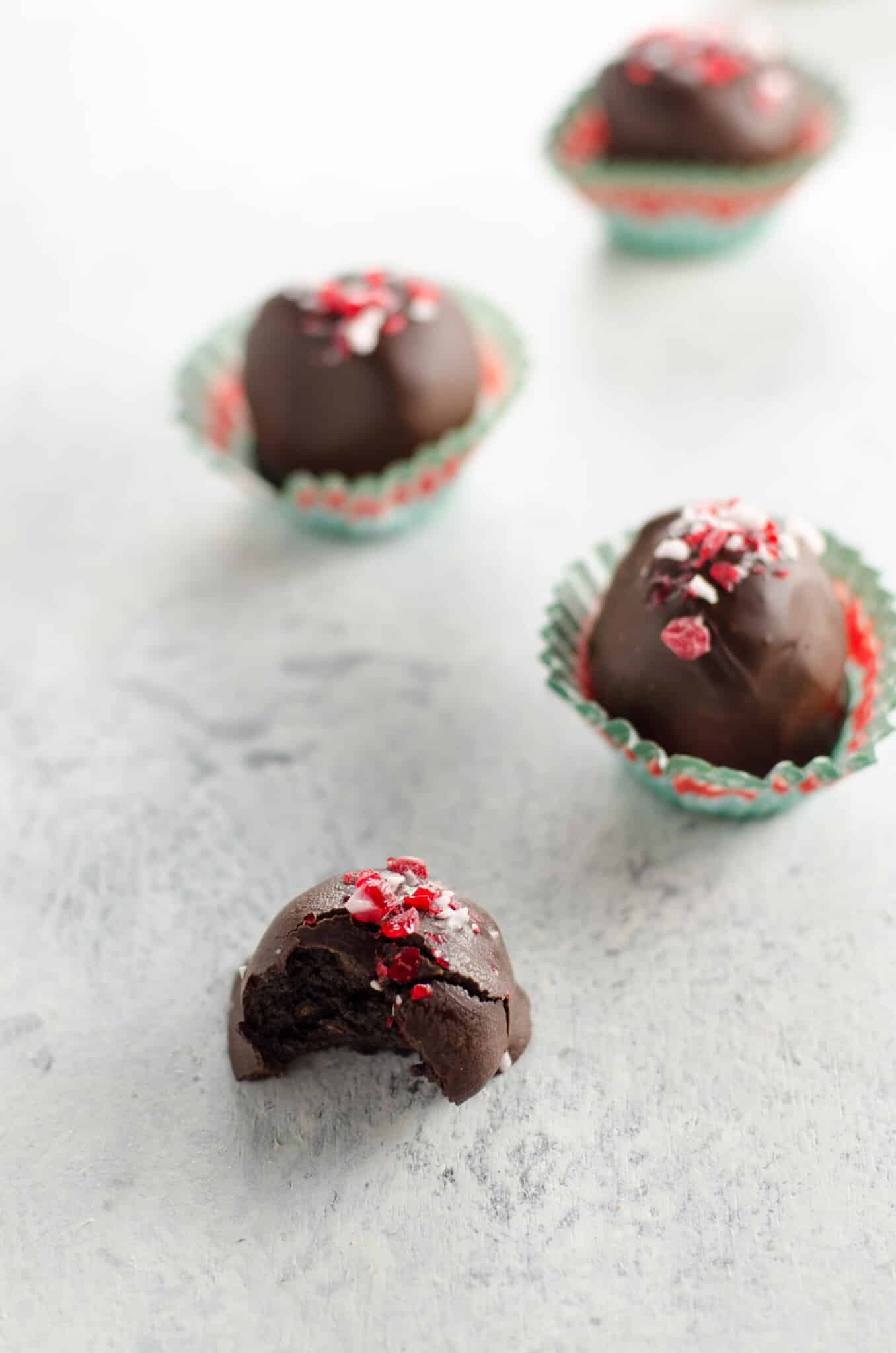 Peppermint Oreo Truffles on a light background, one with a bite out of it
