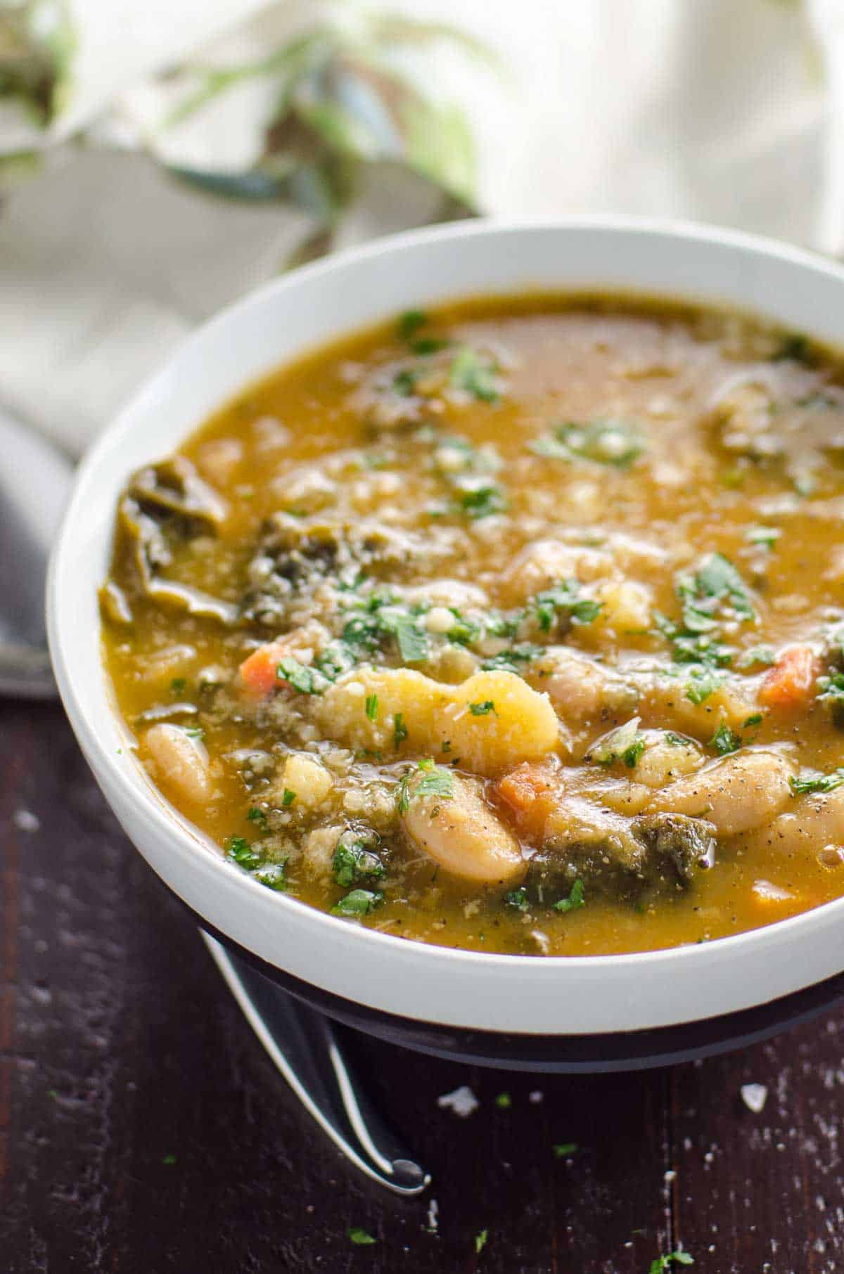 easy kale soup with white beans and potatoes in a bowl with a spoon