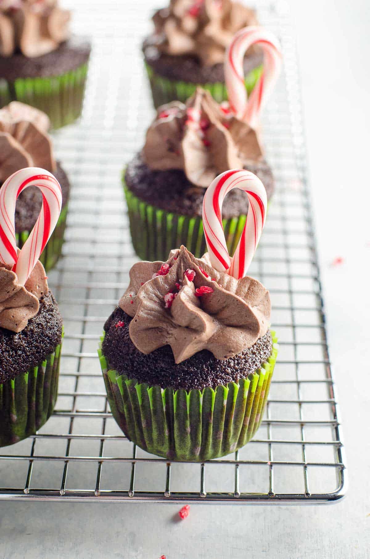chocolate candy cane cupcakes on a baking rack