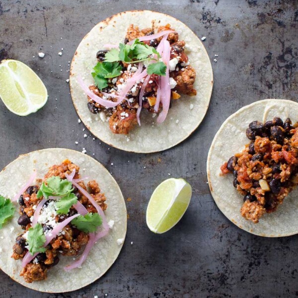 ground pork tacos and lime wedges