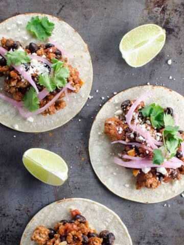 ground pork tacos and lime wedges