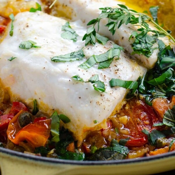 striped bass with brightly colored vegetables in a cast iron braiser
