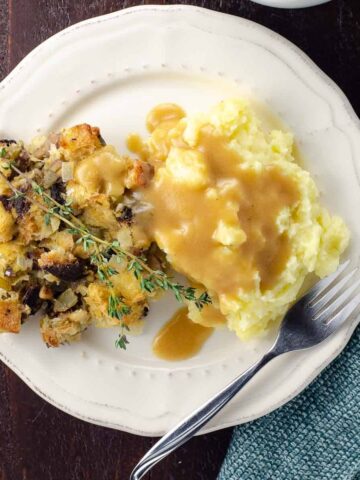 a plate with stuffing, gravy, and old fashioned mashed potatoes for a crowd