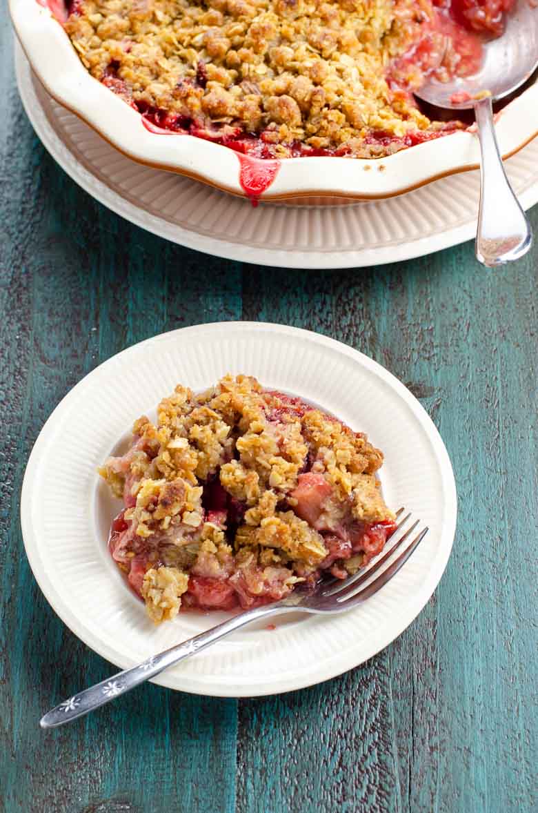 strawberry rhubarb crisp on a plate with a fork