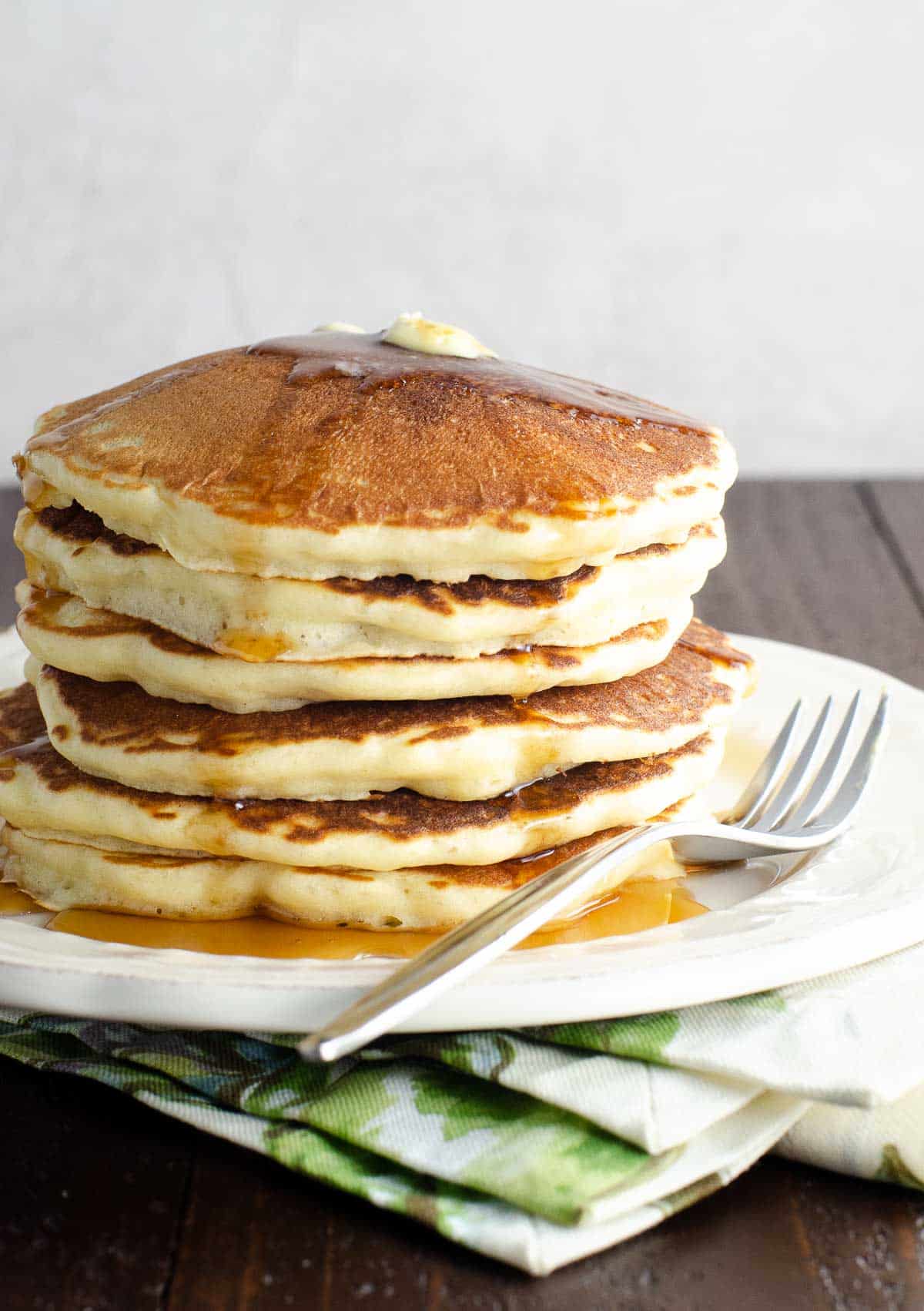 a stack of old fashioned pancakes on a plate with a fork