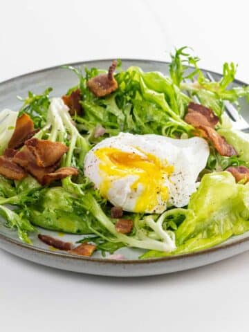 Lyonnaise salad on a plate with a fork