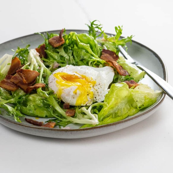 Lyonnaise salad on a plate with a fork