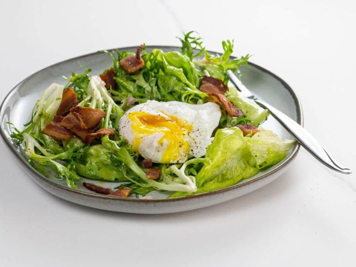 Lyonnaise salad on a plate with a fork