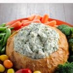 knorr spinach dip in a bread bowl with grape tomatoes, broccoli, baby carrots, and snap peas