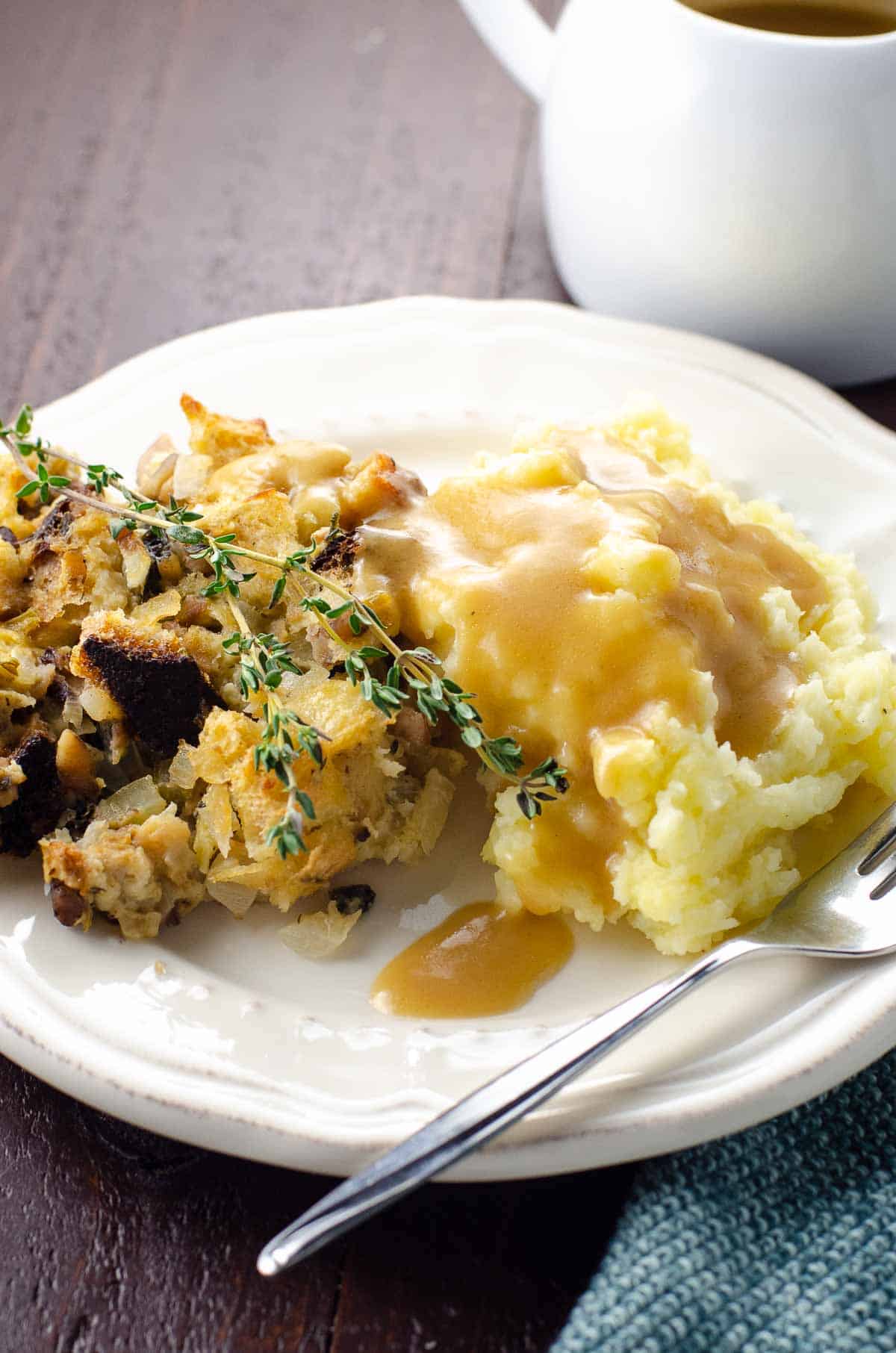 vegan stuffing and mashed potatoes on a plate with vegan gravy