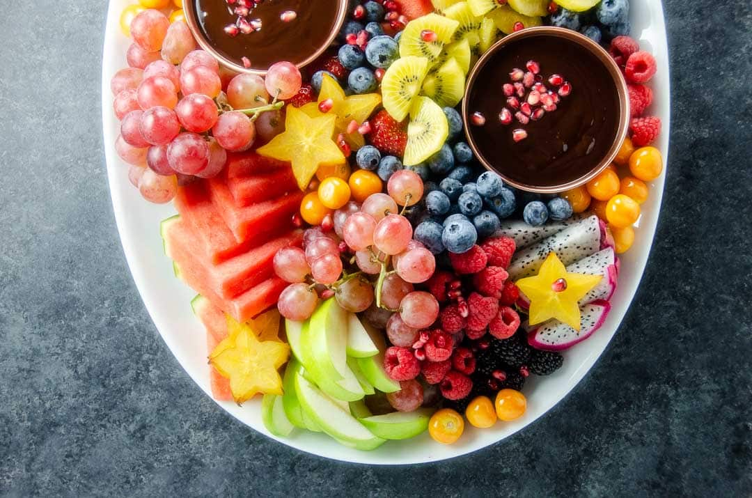 a huge fruit platter with chocolate dip