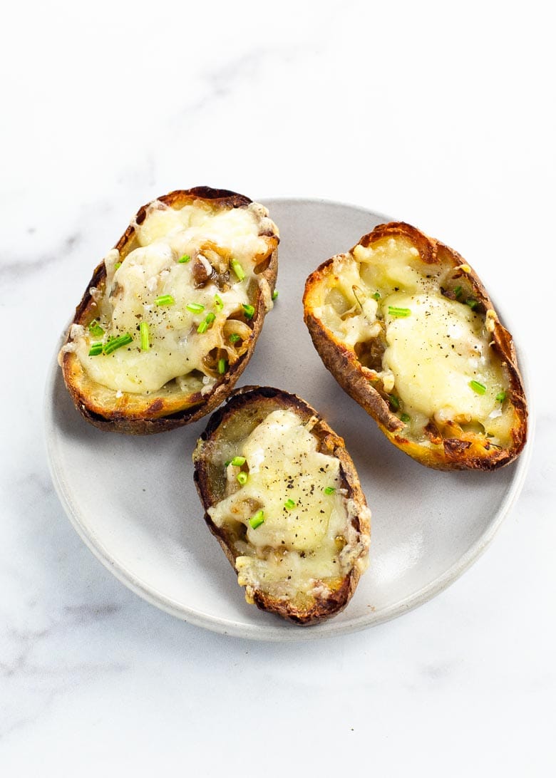 three french onion soup potato skins on a small gray plate on a marble background