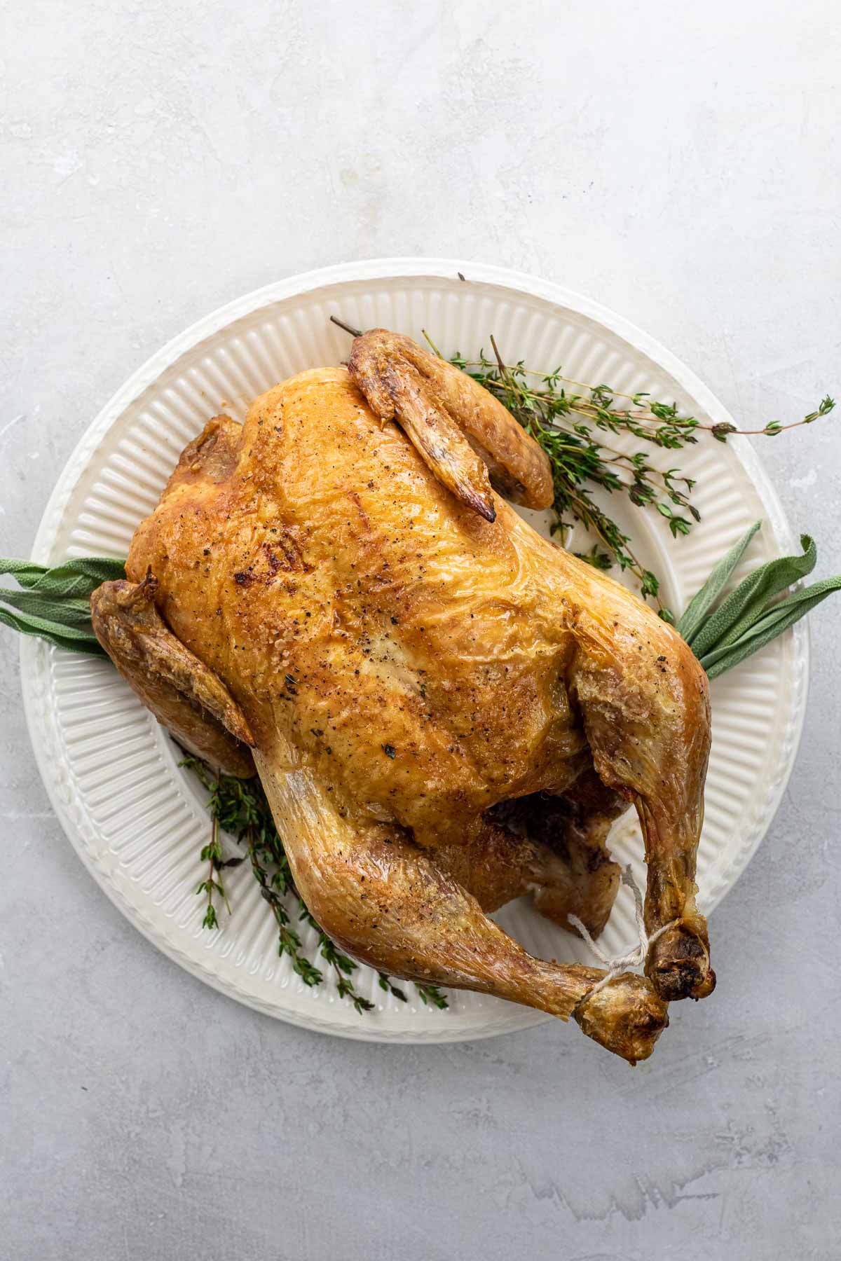our old fashioned roast chicken recipe on a platter with thyme and sage