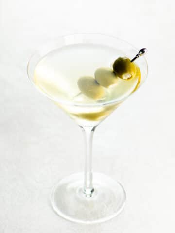 best dirty martini recipe in a glass on a light background