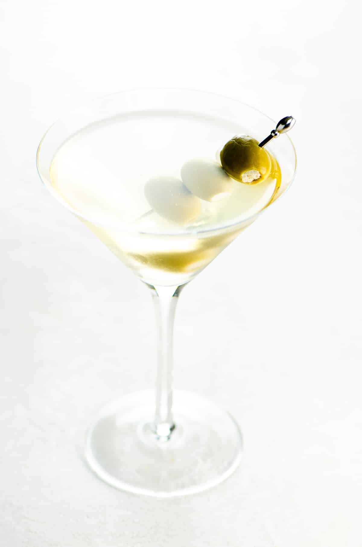 best dirty martini recipe in a glass on a light background