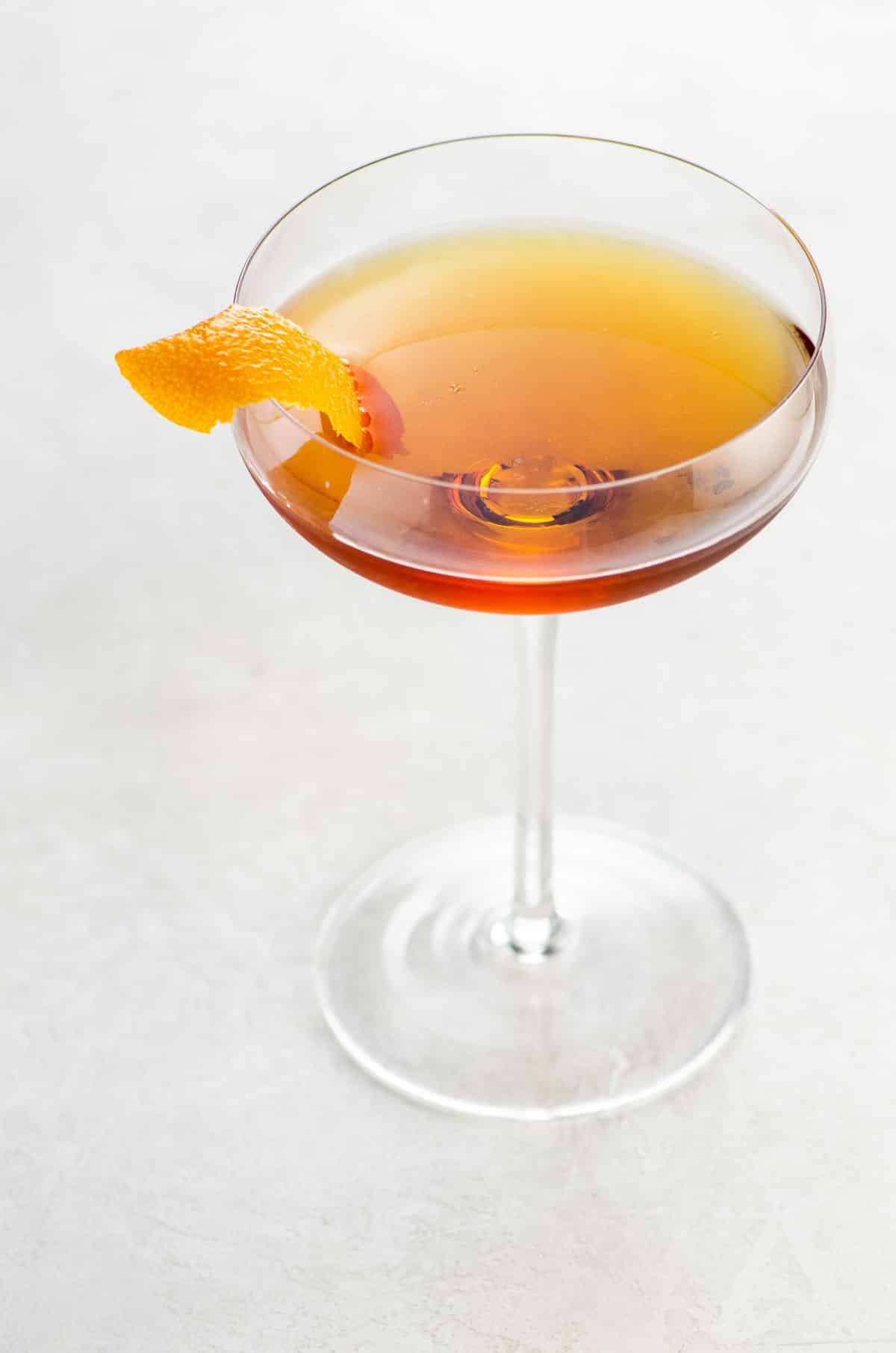 Martinez cocktail recipe with gin, luxardo, and sweet vermouth in a coupe glass garnished with an orange twist
