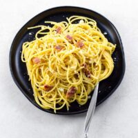 traditional italian spaghetti alla carbonara on a plate with a fork