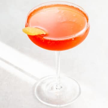 a Grape Gatsby aperol champagne verjus cocktail in a coupe glass