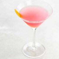 a pink cosmo (cosmopolitan cocktail recipe) in a martini glass