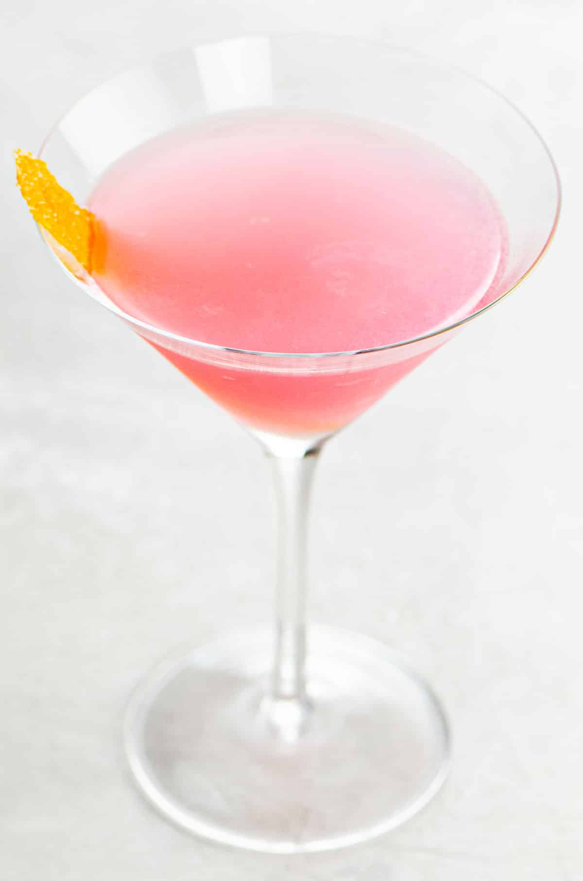 a pink cosmo (cosmopolitan cocktail recipe) in a martini glass