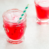bright pink rhubarb juice in glasses with striped straws