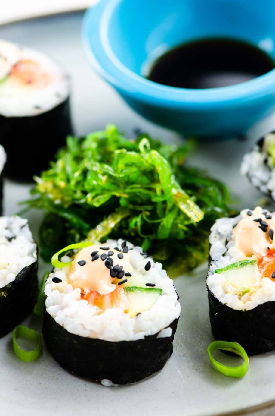 homemade sushi: spicy salmon roll, seaweed salad, and soy sauce