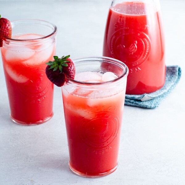 carafe and two glasses of strawberry agua fresca