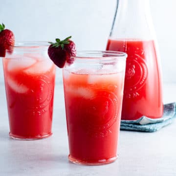 carafe and two glasses of strawberry agua fresca