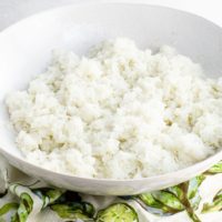sushi rice in a shallow white bowl over a napkin