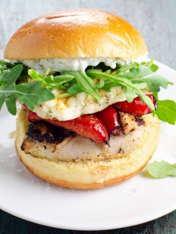 A grilled chicken sandwich with halloumi on a bun