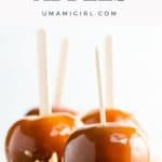 four caramel apples on a wooden board