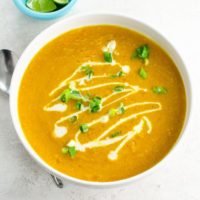 a white bowl of carrot and lentil soup