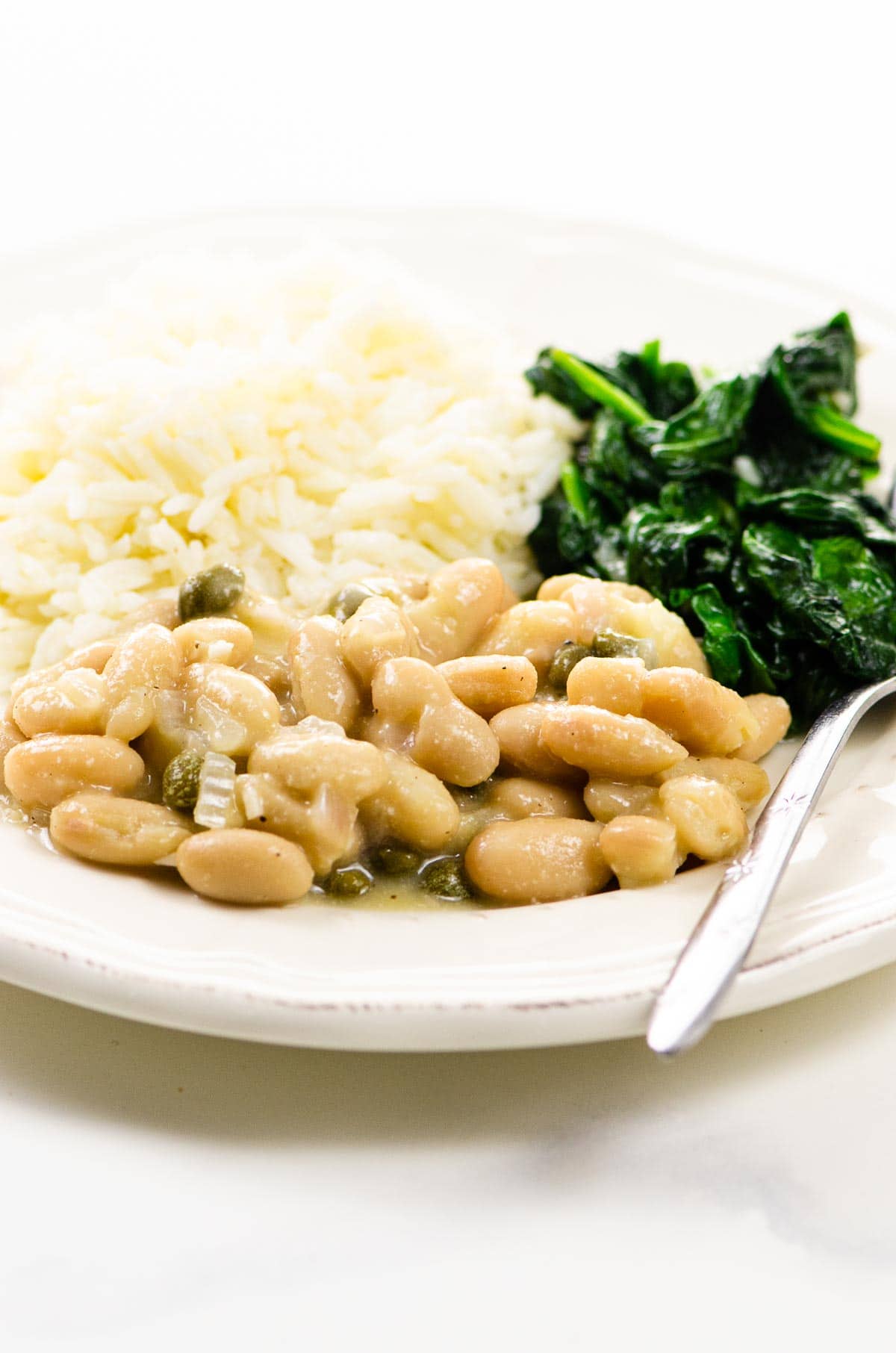 Garlicky Sauteed Spinach and Vegetarian Piccata with Cannellini Beans on a plate
