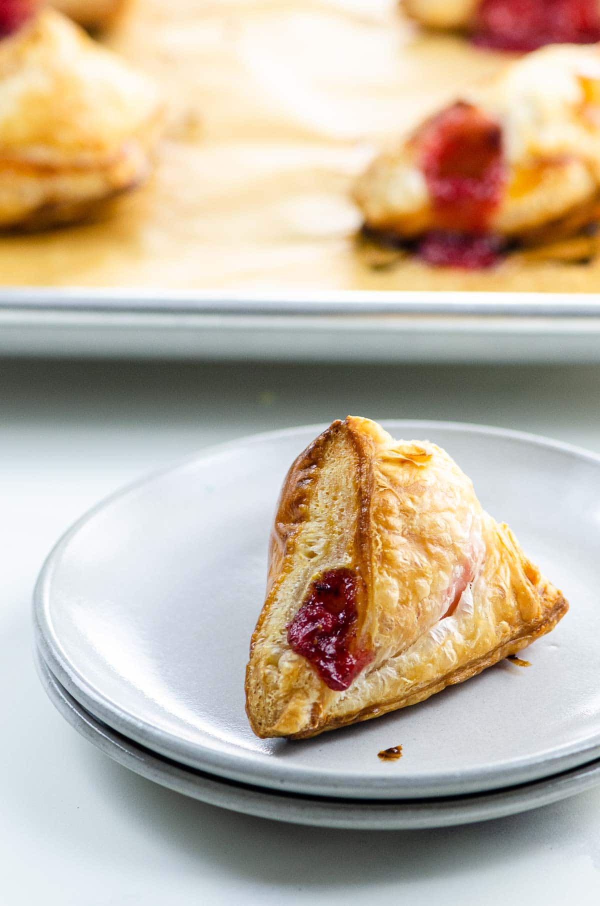strawberry turnovers on a plate and sheet pan