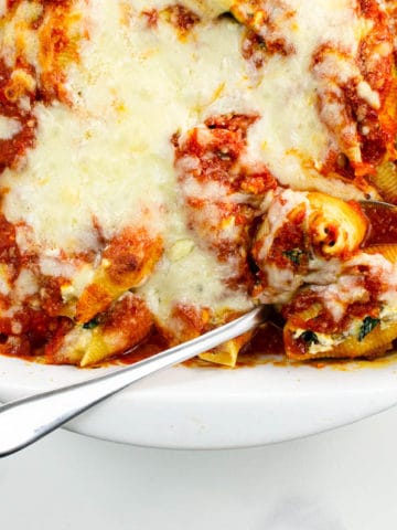a baking pan of stuffed pasta shells with ricotta, spinach, and mushrooms