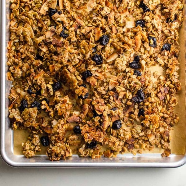 cinnamon granola with almonds, coconut, and dried cherries on a sheet pan