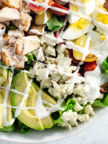 cobb salad with ranch dressing in a white bowl