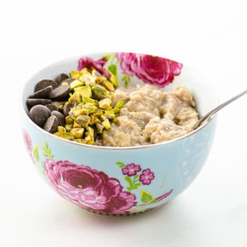 creamy oatmeal with chocolate chips and chopped pistachios in a pretty bowl