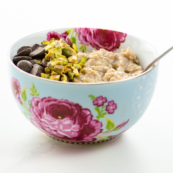 creamy oatmeal with chocolate chips and chopped pistachios in a pretty bowl
