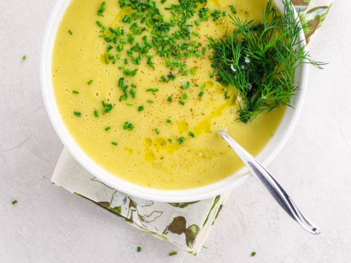 potage parmentier (potato leek soup) in a white bowl garnished with dill and chopped chives